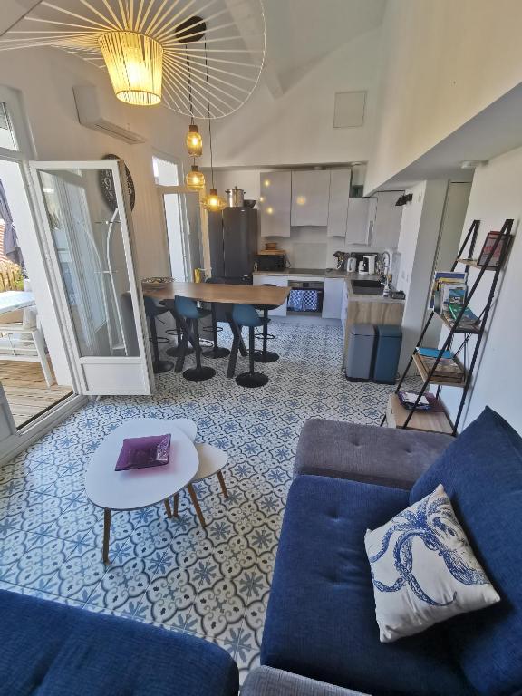 un salon avec un canapé bleu et une table dans l'établissement T3 terrasse classé 4 étoiles le Poulpe 200m front de mer, à Banyuls-sur-Mer