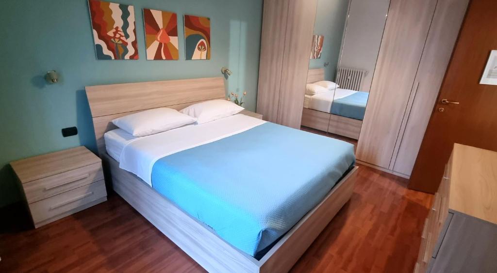1 dormitorio con 1 cama blanca grande y suelo de madera en Metro Suite Milano, en Milán