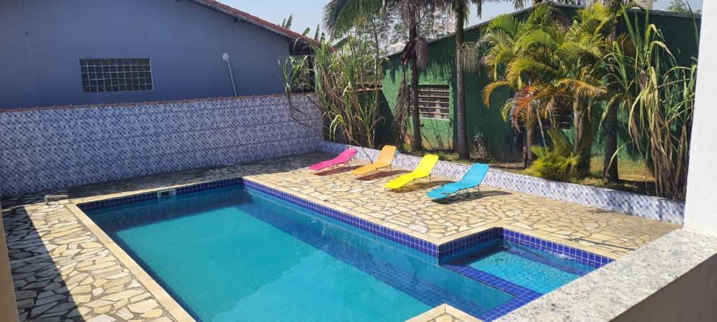 une piscine avec deux chaises longues à côté dans l'établissement Sinta-se em casa com diversão!, à São Paulo