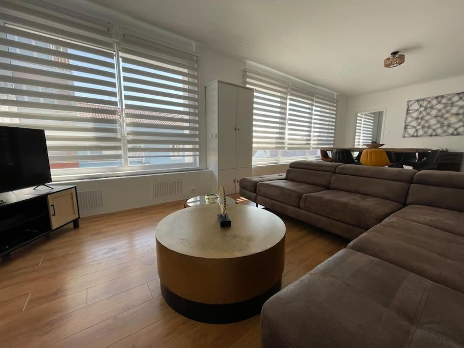 un salon avec un canapé et une table basse dans l'établissement Appartement élégant proche mer, à Dunkerque