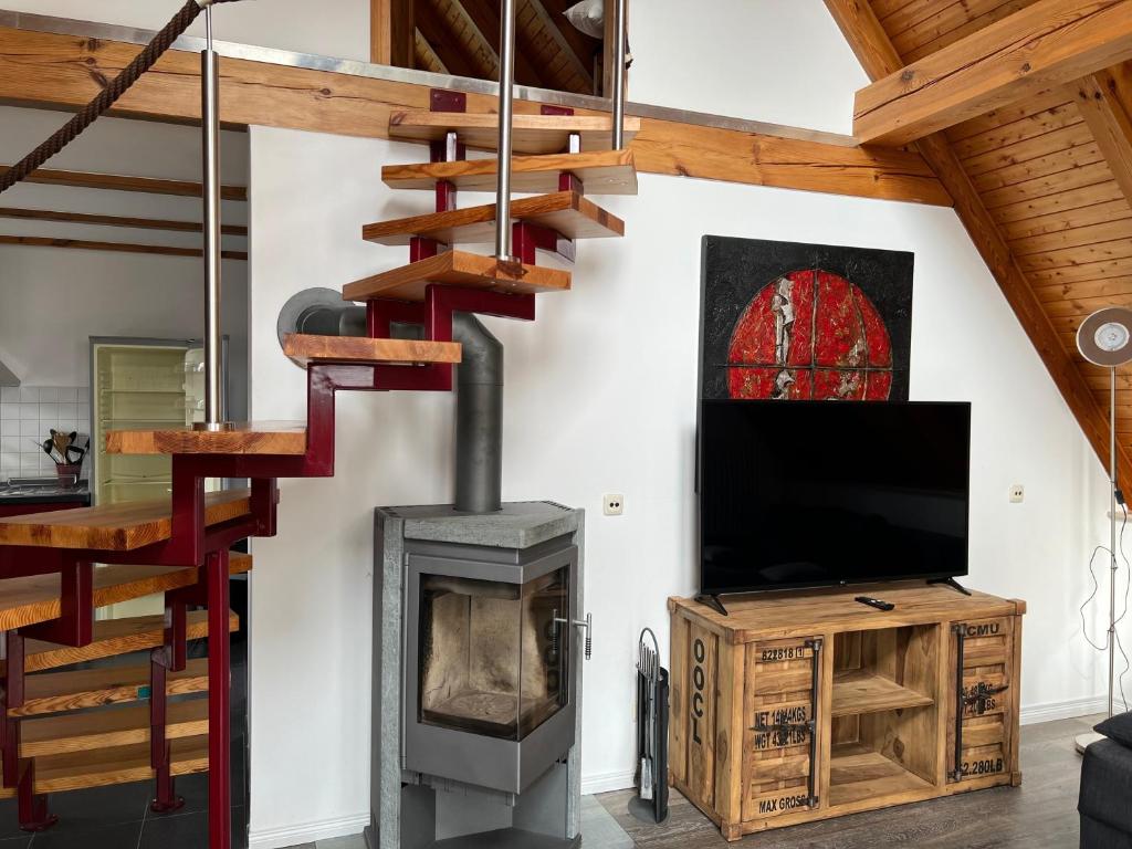 a living room with a fireplace and a staircase at Müritzblick OG in Marienfelde