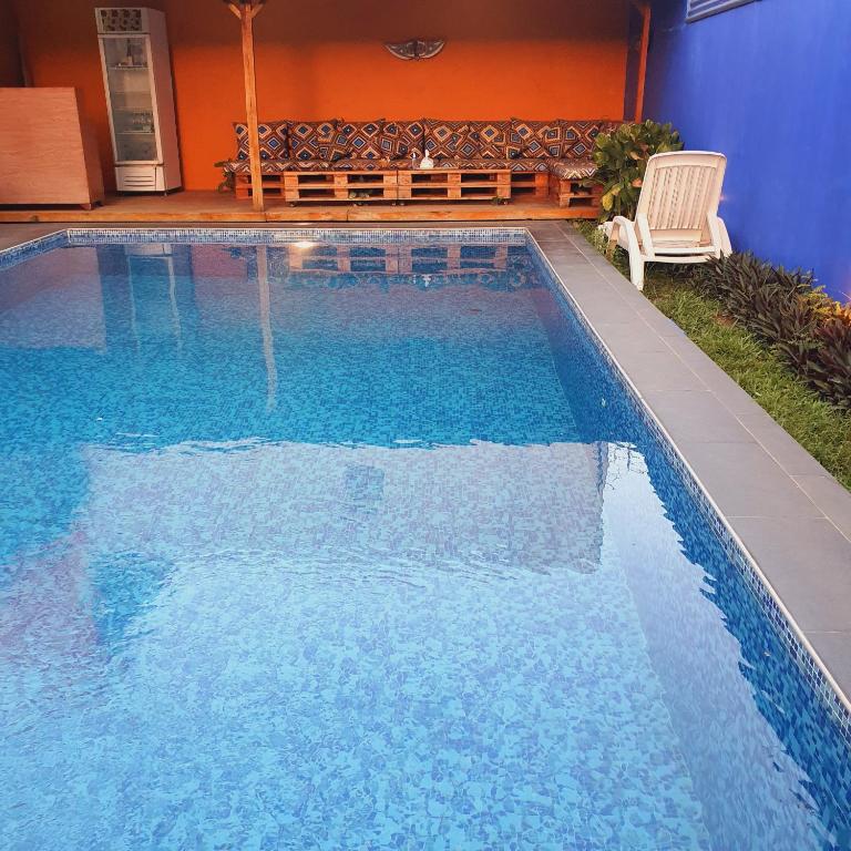 a swimming pool with a chair and a bench at Villa Cacao in Abidjan