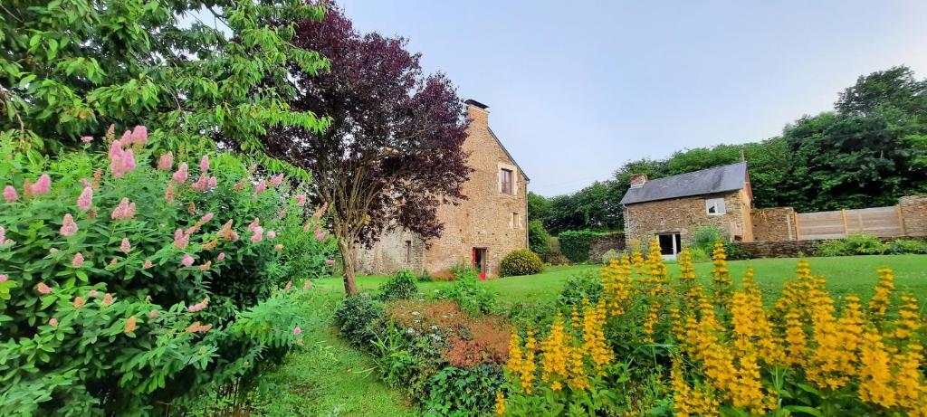 une ancienne maison en pierre et un jardin fleuri dans l'établissement Les gîtes de La Petite Taupe - Akotee, à Saint-Omer