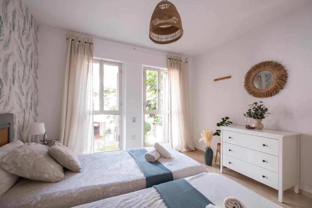 sypialnia z dwoma łóżkami i oknem w obiekcie Aquamarine apartment in Marina Sotogrande w mieście Sotogrande