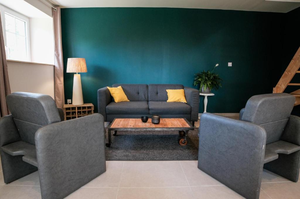 un salon avec un canapé et deux chaises dans l'établissement Un gîte en Creuse, à Bord-Saint-Georges
