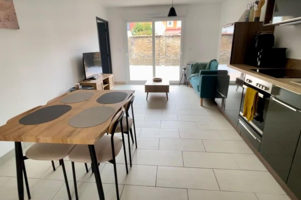 une cuisine et une salle à manger avec une table et des chaises dans l'établissement Appartement Lion de Flandres, à Dunkerque