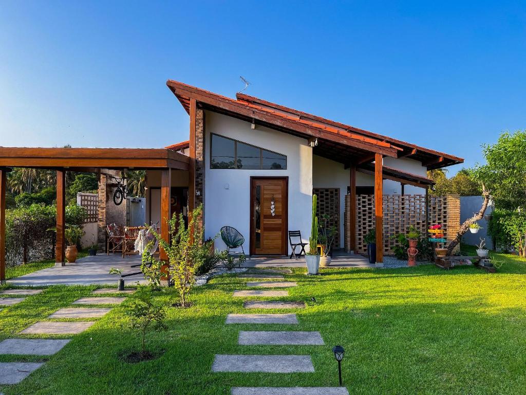 una casa con un sentiero che conduce al cortile anteriore di Casa em Ipioca | piscina, área gourmet, Hibiscus Beach Club a Ipioca