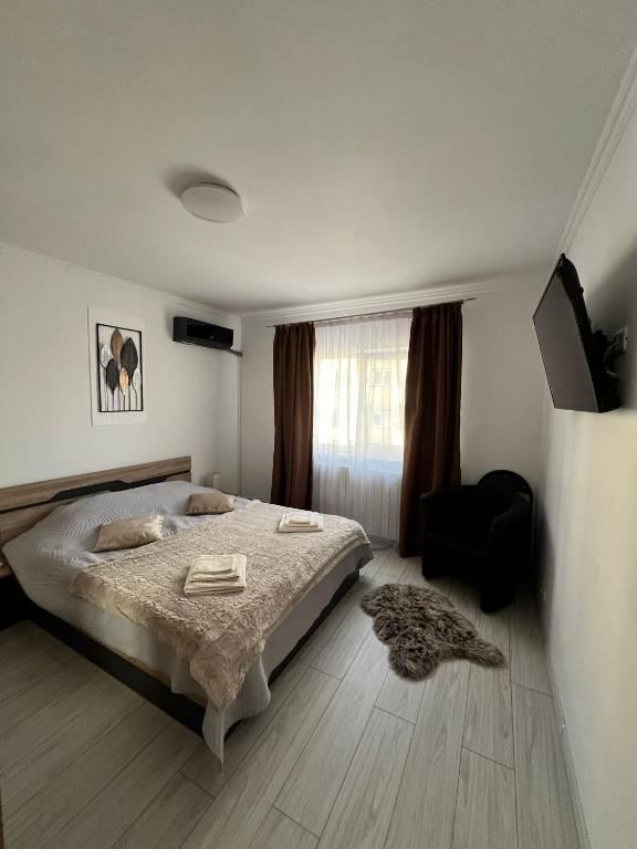 a bedroom with a bed and a chair and a window at Zen Studio Onesti in Onești