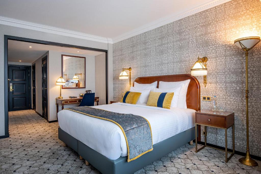 a hotel room with a large bed and a lamp at Hotel Barsey by Warwick in Brussels