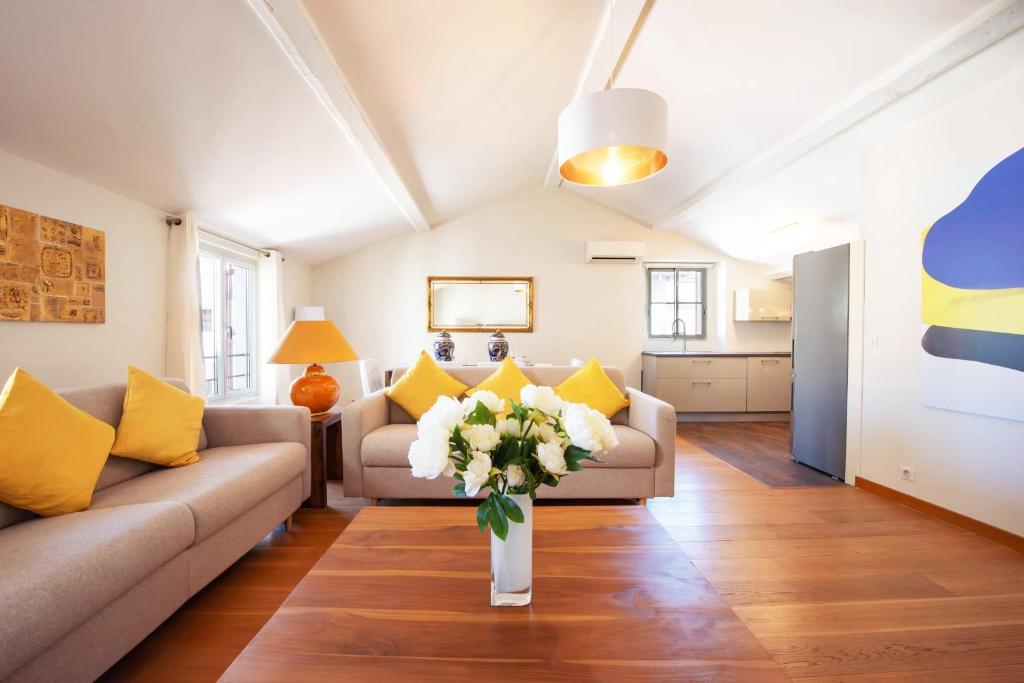 - un salon avec un canapé et un vase de fleurs dans l'établissement Exquisite 2-Br apartment 3 minutes from la Croisette, à Cannes