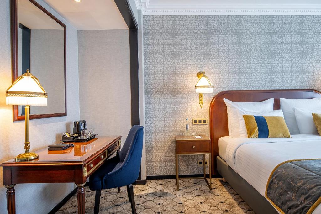 a hotel room with a bed and a desk and a bed and a desk at Hotel Barsey by Warwick in Brussels