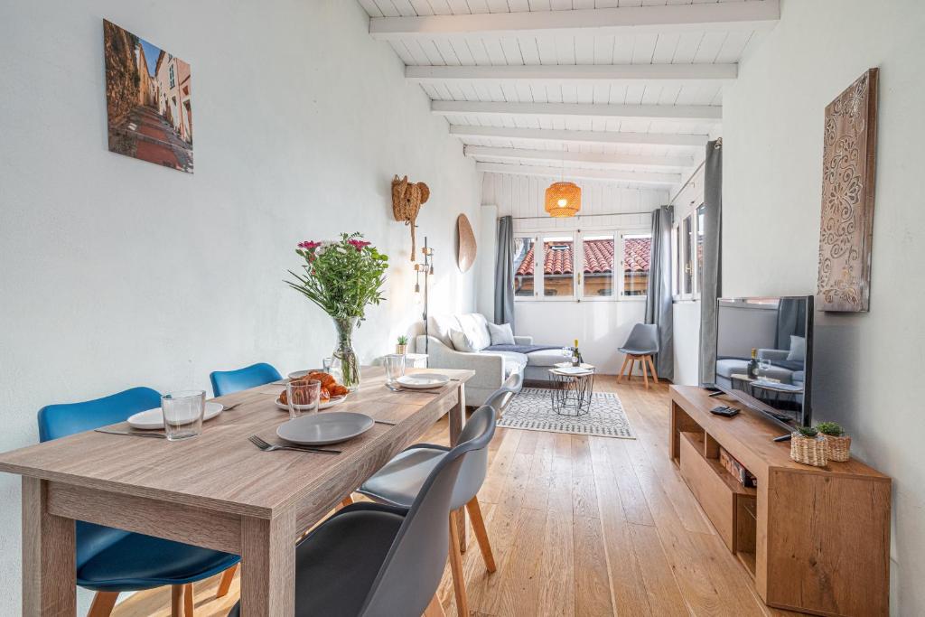 - une salle à manger et un salon avec une table et des chaises en bois dans l'établissement Le Bougainvillier Menton Vieille Ville, à Menton
