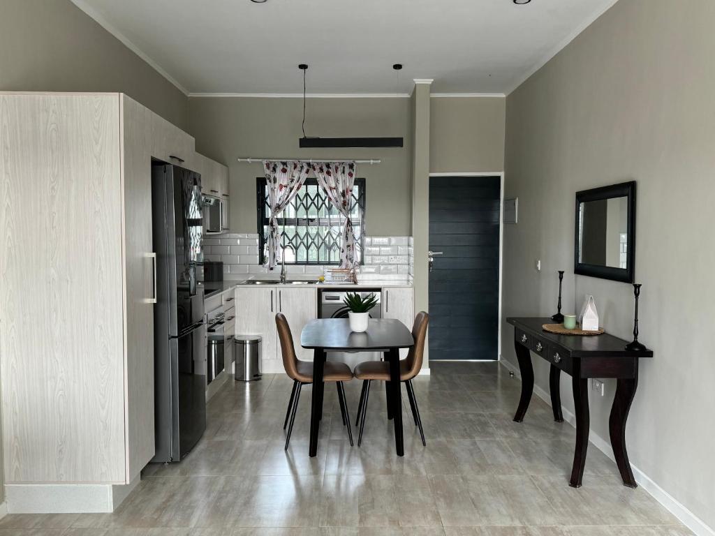 a kitchen and dining room with a table and chairs at SiaMo Suite in Gaborone