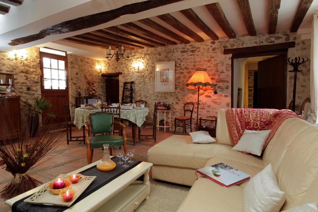 a living room with a couch and a table at Ferme Historique Jean De La Fontaine et ses chambres d'hôtes Hammam-Spa - 4 étoiles in Chierry