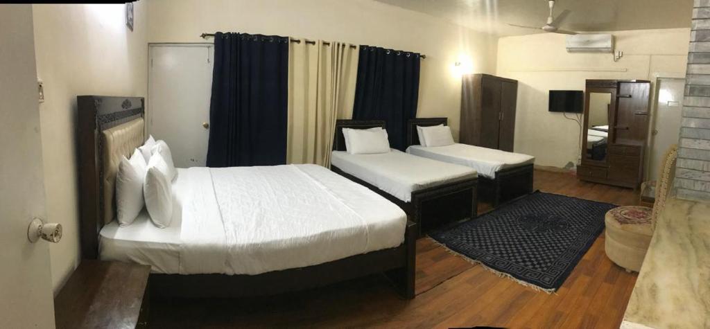 Una habitación de hotel con dos camas y un baño. en Luxury Moon Guest House, en Islamabad