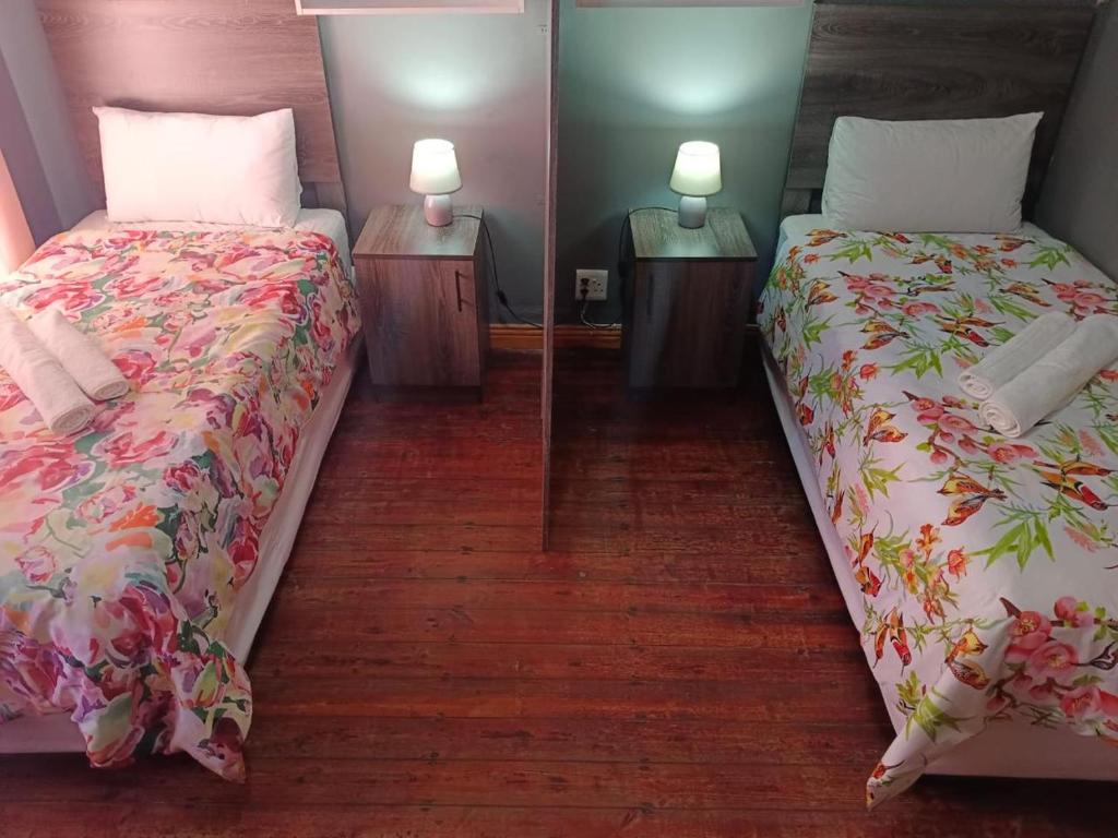 a bedroom with two beds and two lamps on tables at Brix 7 single beds in Johannesburg