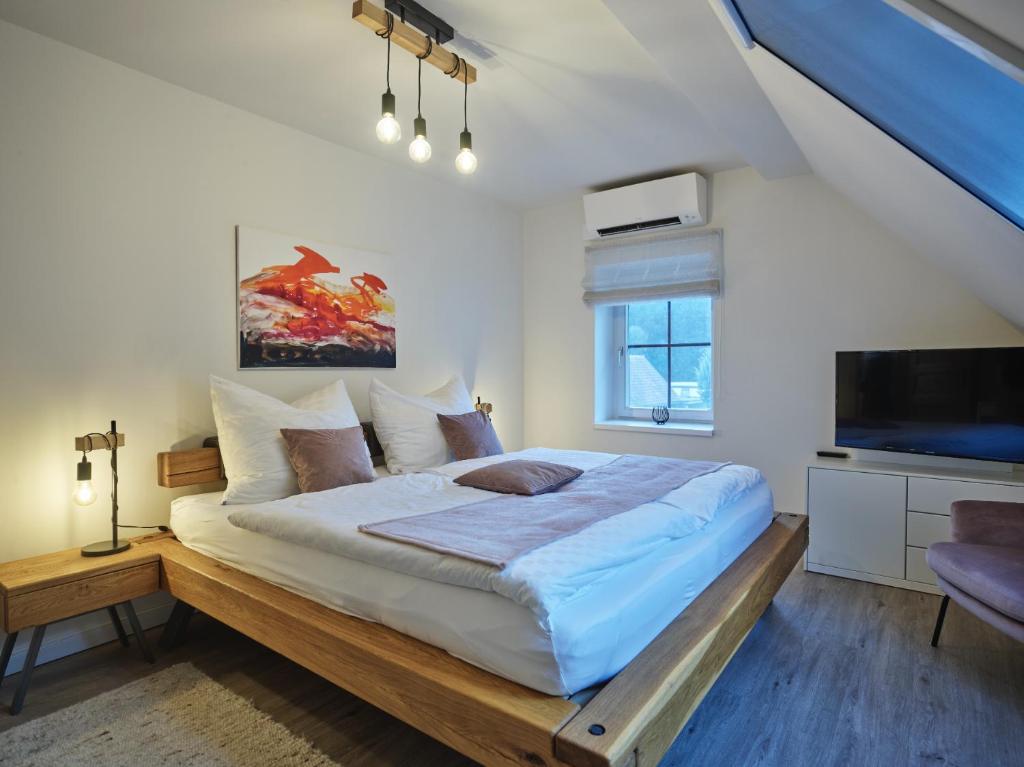 a bedroom with a large bed and a tv at Restaurant Broadmoar Appartments in Muttendorf
