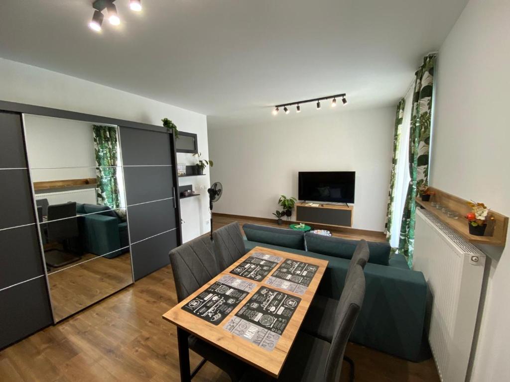 un soggiorno con un tavolo e un divano di EM Room a Cracovia