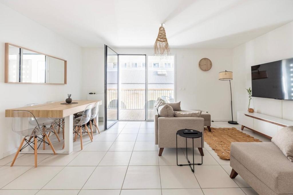 un salon blanc avec une table et un canapé dans l'établissement Amédée Saint Germain, à Bordeaux