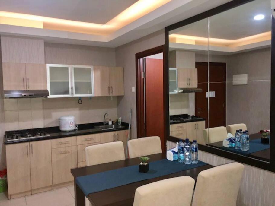 a kitchen with a table and chairs in a room at Thamrin Residence City Home in Jakarta