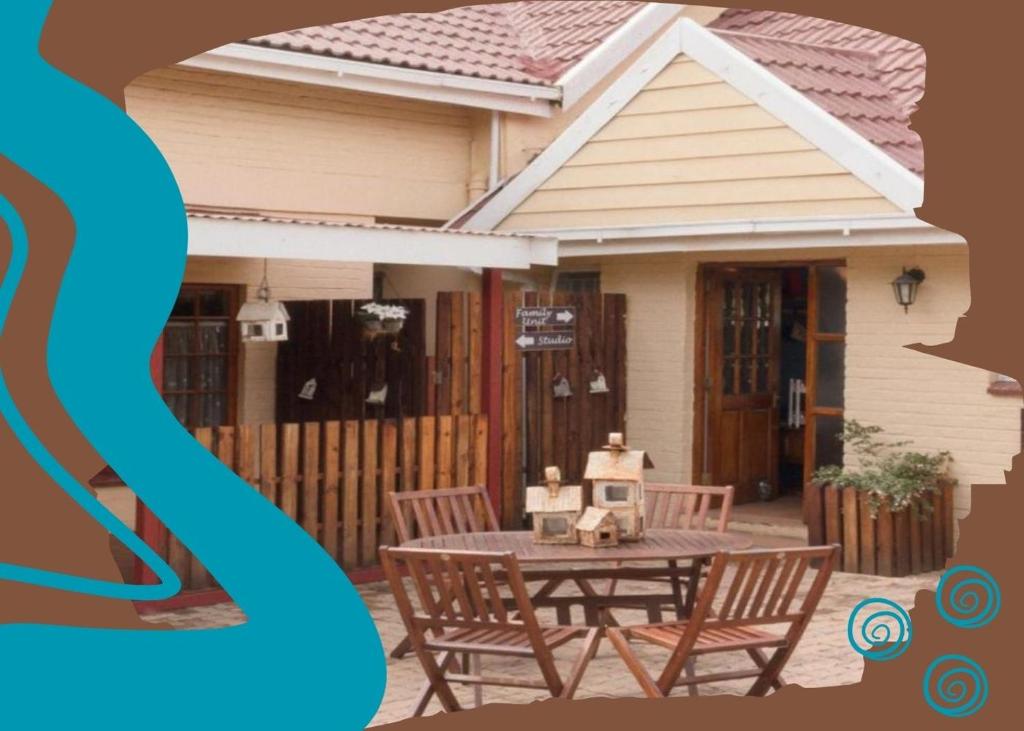 a house with a table and chairs in front of it at Guest House Mooigezicht in Clarens