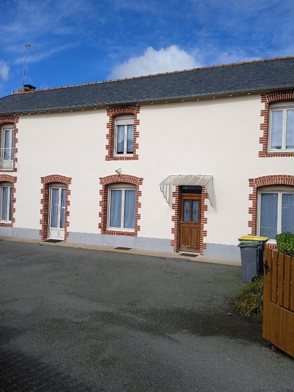une maison blanche avec une porte et des fenêtres marron dans l'établissement Ty Samy et Seb, à Mauron