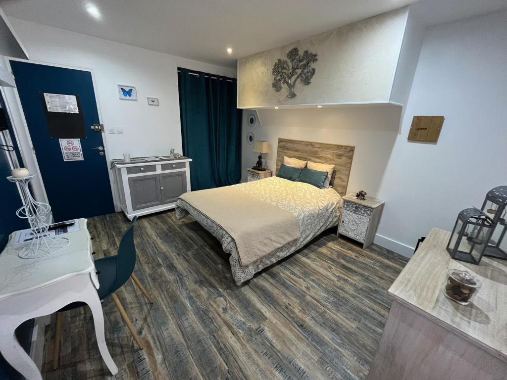 sypialnia z łóżkiem i biurkiem w obiekcie Chambres d'hôtes à la forge du Coglais w mieście La Selle-en-Coglès