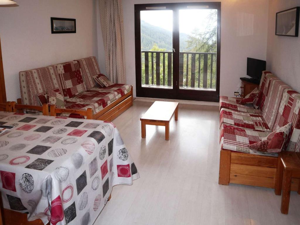- une chambre avec un lit et deux chaises et un balcon dans l'établissement Duplex cosy 8 pers. au pied des pistes – Balcon exposé ouest, belles prestations, cœur de station - FR-1-322-7, aux Orres