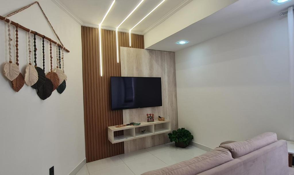 a living room with a couch and a flat screen tv at Tempo de Aconchego Hospedagens Tambaú 100m da Praia in João Pessoa