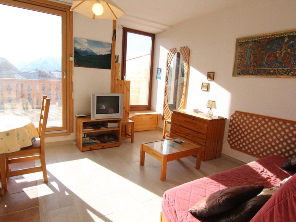 un salon avec un canapé et une télévision dans l'établissement Studio 4 pers. 23m² - Centre, Télécentre, Animaux OK, Terrasse Sud - FR-1-405-182, à L'Alpe-d'Huez