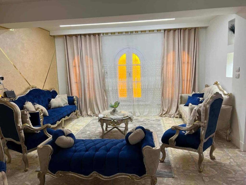 un salon avec des canapés bleus et une table dans l'établissement الشاطئ الفضي, à El-Shaikh Mabrouk
