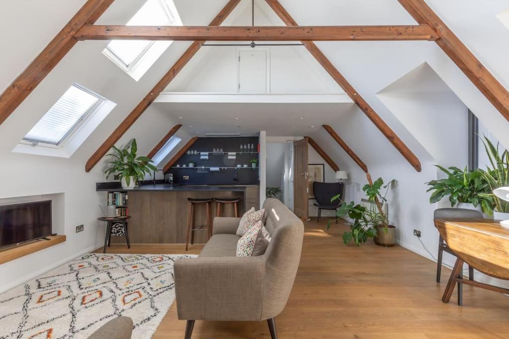 a living room with a vaulted ceiling with skylights at The Loft in Faygate