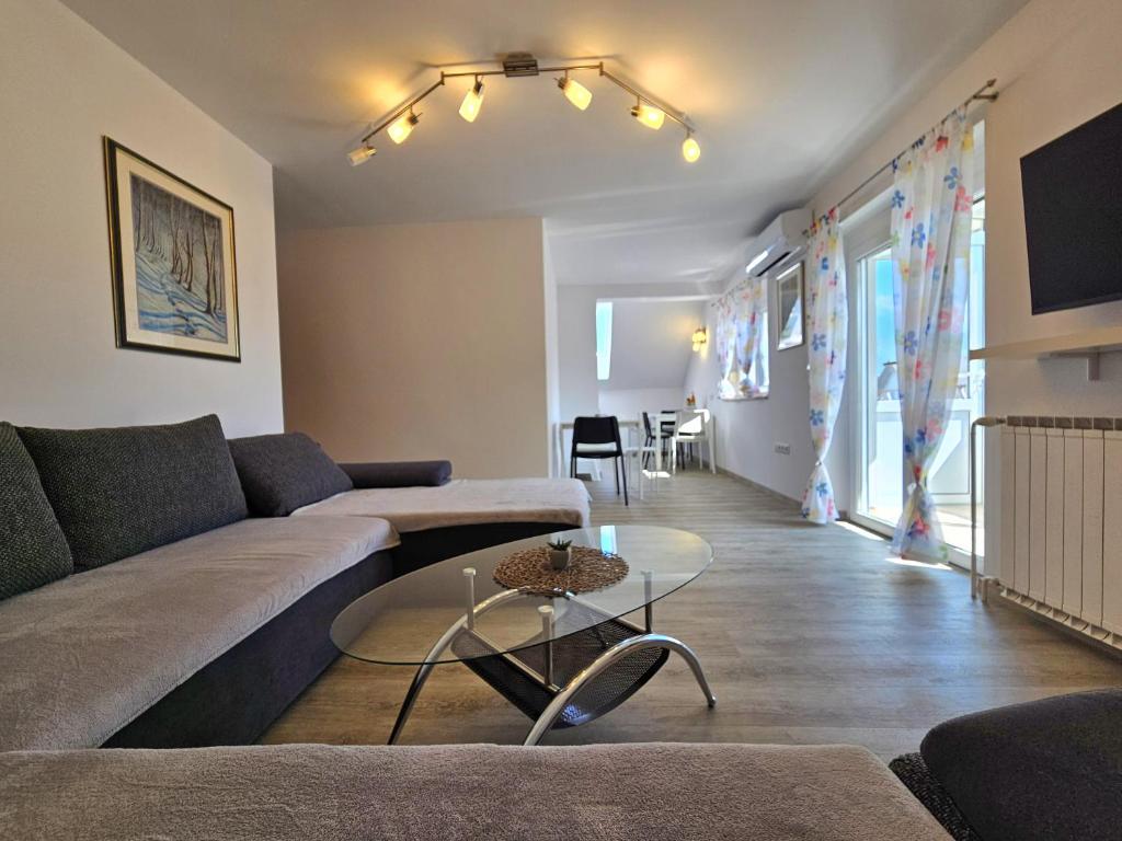una sala de estar con un sofá y una mesa en Green Hill Apartments, en Žirovnica