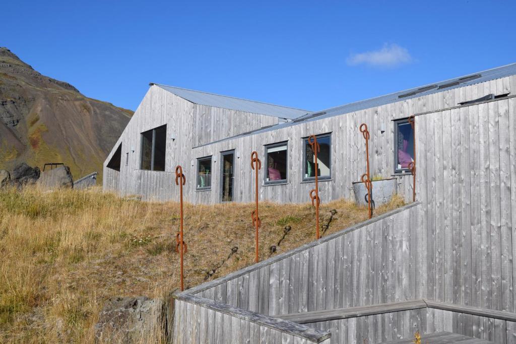 un edificio grigio con finestre su un campo di The Holy Ram Farm-Hotel a Snæfellsbær
