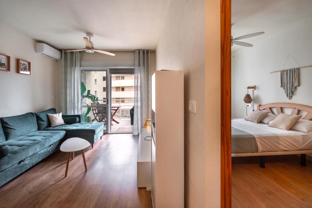 阿勒纳勒斯德尔索尔Dunesunbreak Arenales的客厅里有一张蓝色沙发和一张床