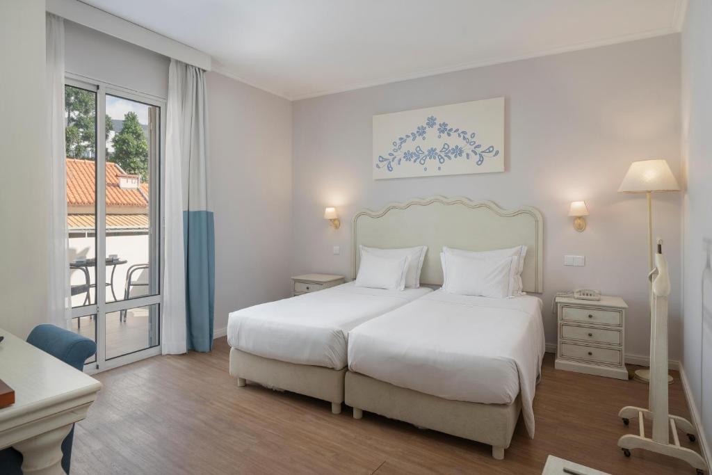 Postel nebo postele na pokoji v ubytování Hotel Madeira
