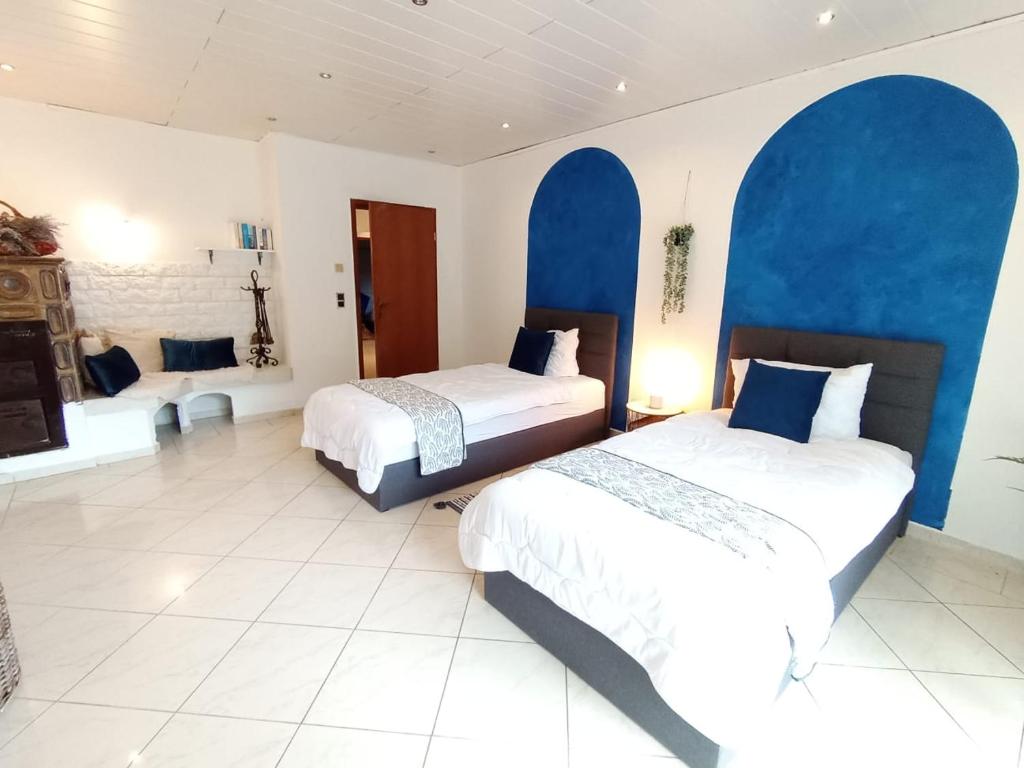 due letti in una stanza con archi blu di Relaxe Wohnung Bergstraße HP a Ober-Laudenbach