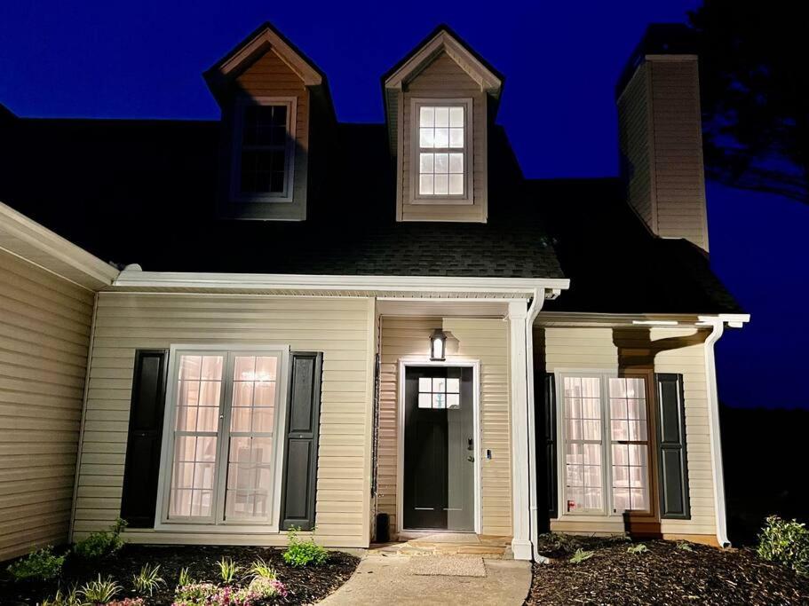a white house with a black roof at Lake Lanier House 2 in Gainesville