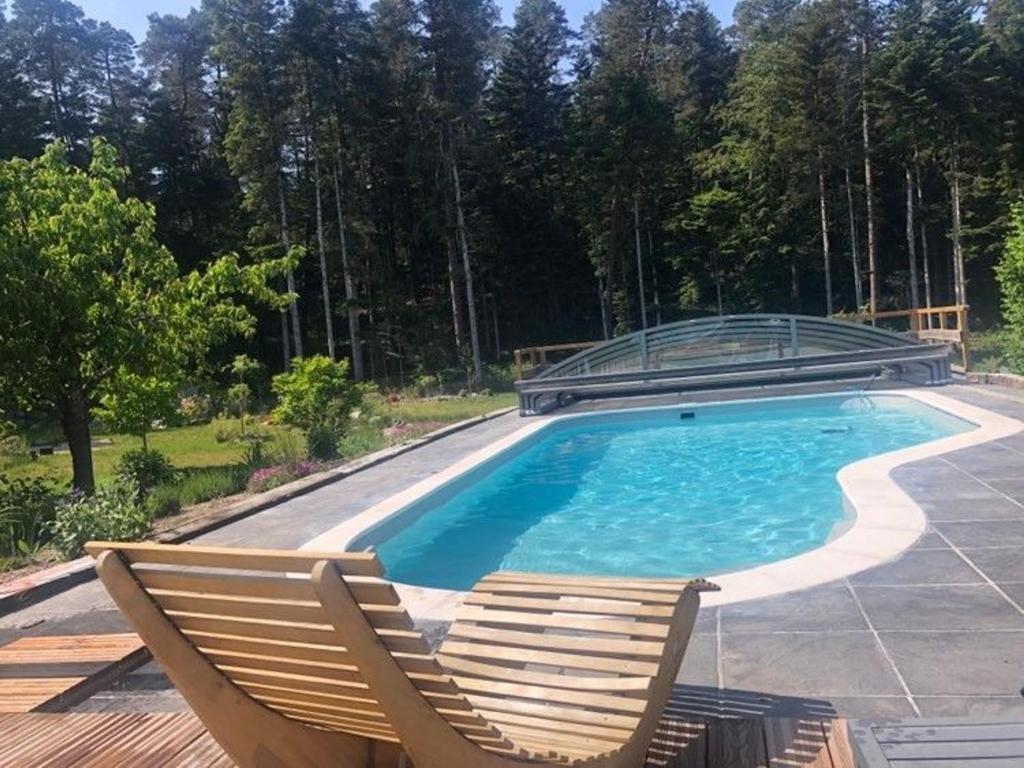 a swimming pool with two deck chairs and a swimming poolvisorangering at Gîte paisible avec piscine, terrasse et Wifi en pleine forêt pour 4 pers - FR-1-589-662 in Saint-Rémy