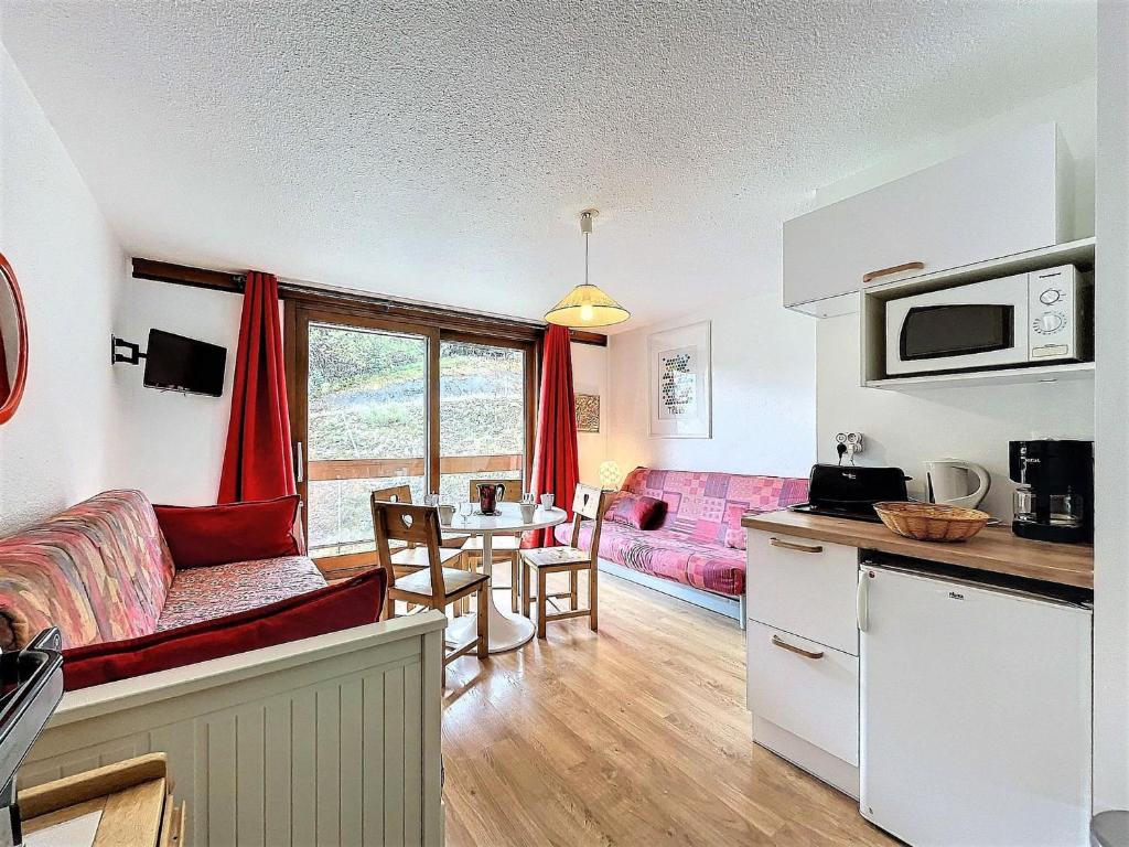 une cuisine et un salon avec un canapé et une table dans l'établissement Studio lumineux skis aux pieds avec balcon, piscine et casier à skis - FR-1-267-294, à Villarembert