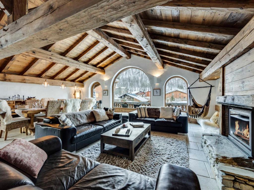 Una sala de estar con sofás y chimenea. en Chalet prestige 4 chambres, hammam, cheminée, conciergerie - FR-1-694-365, en Val dʼIsère