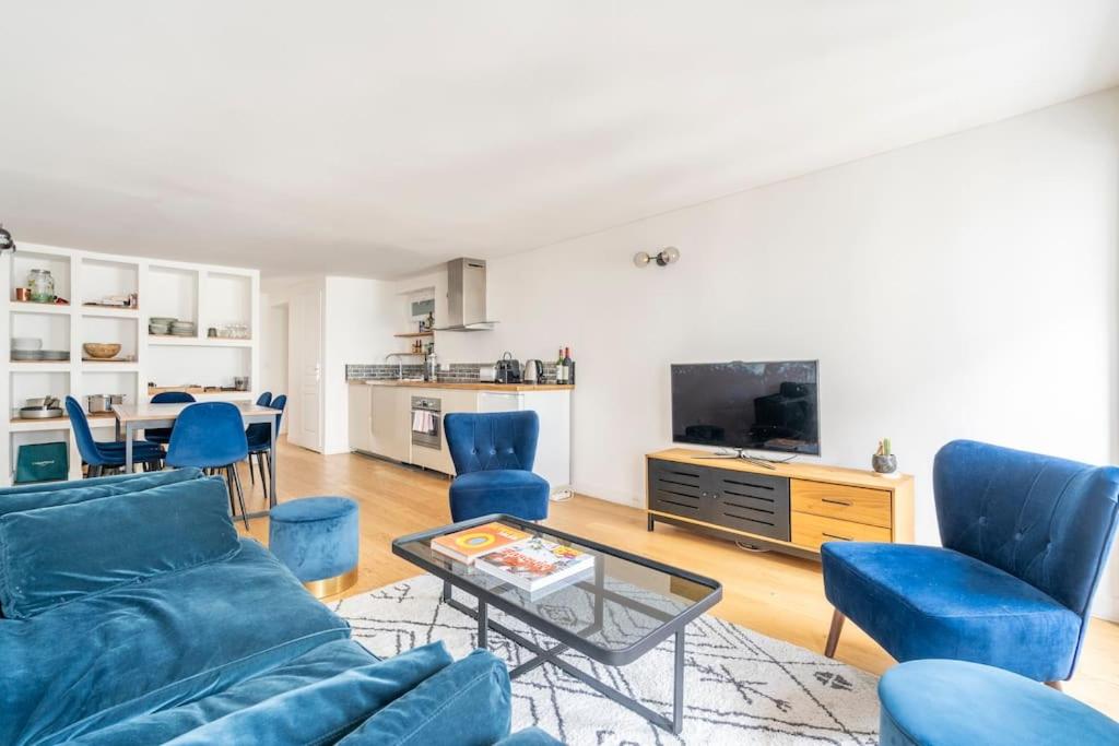 un salon avec un canapé, des chaises et une table dans l'établissement Apt moderne rénové et spacieux, au cœur de Paris, à Paris