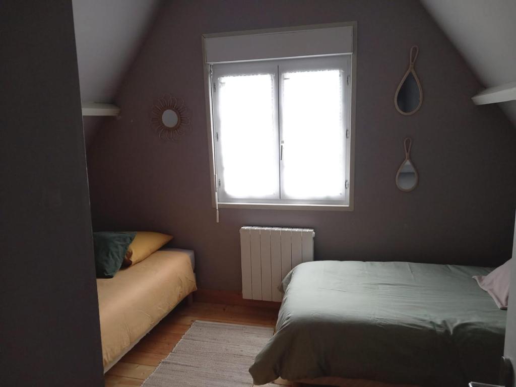 een slaapkamer met een bed, een raam en een bank bij Cottage du Becquet in Épaignes