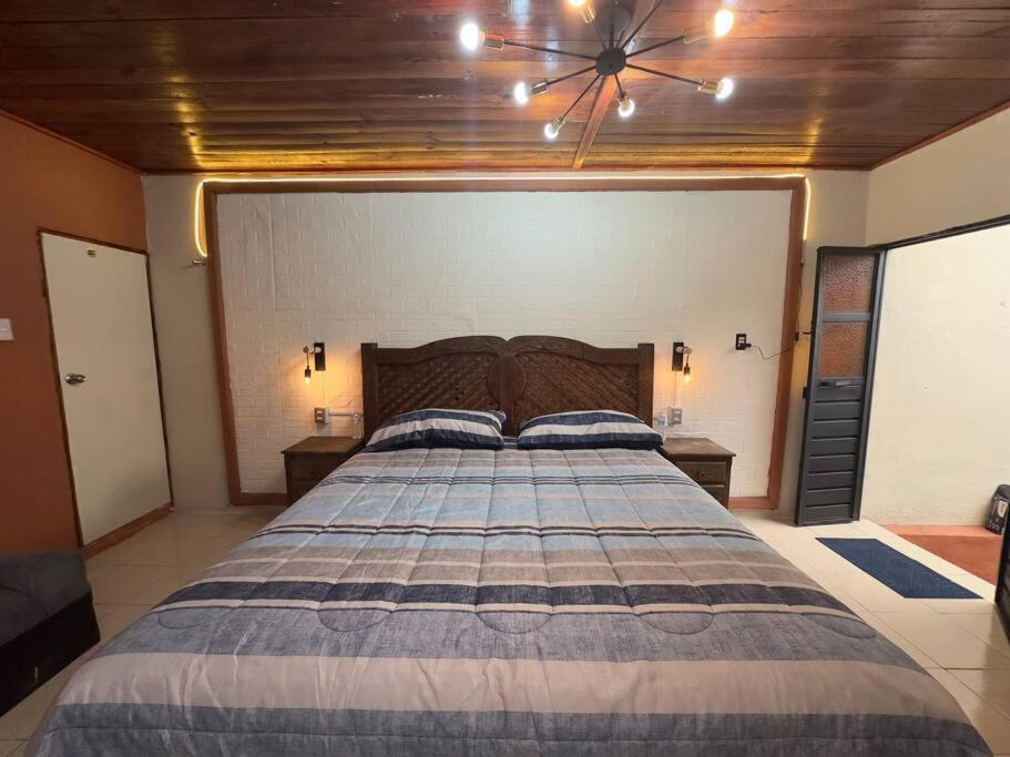 圣克里斯托瓦尔-德拉斯卡萨斯Casa Faro的一间带大床和两个床头柜的卧室