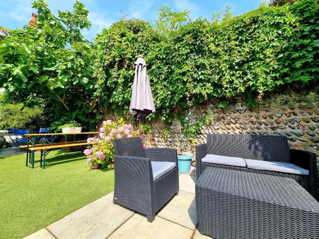 a patio with two chairs and an umbrella at Time & Tide Town House in Seaford