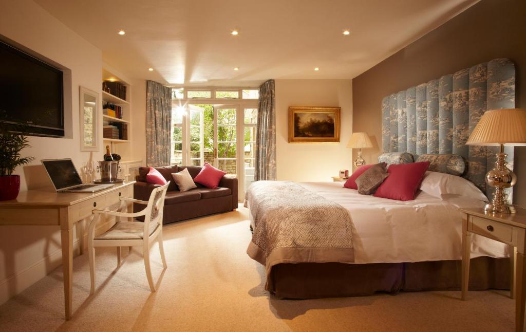 1 dormitorio con cama, escritorio y sofá en The Windsor Town House, en Bath