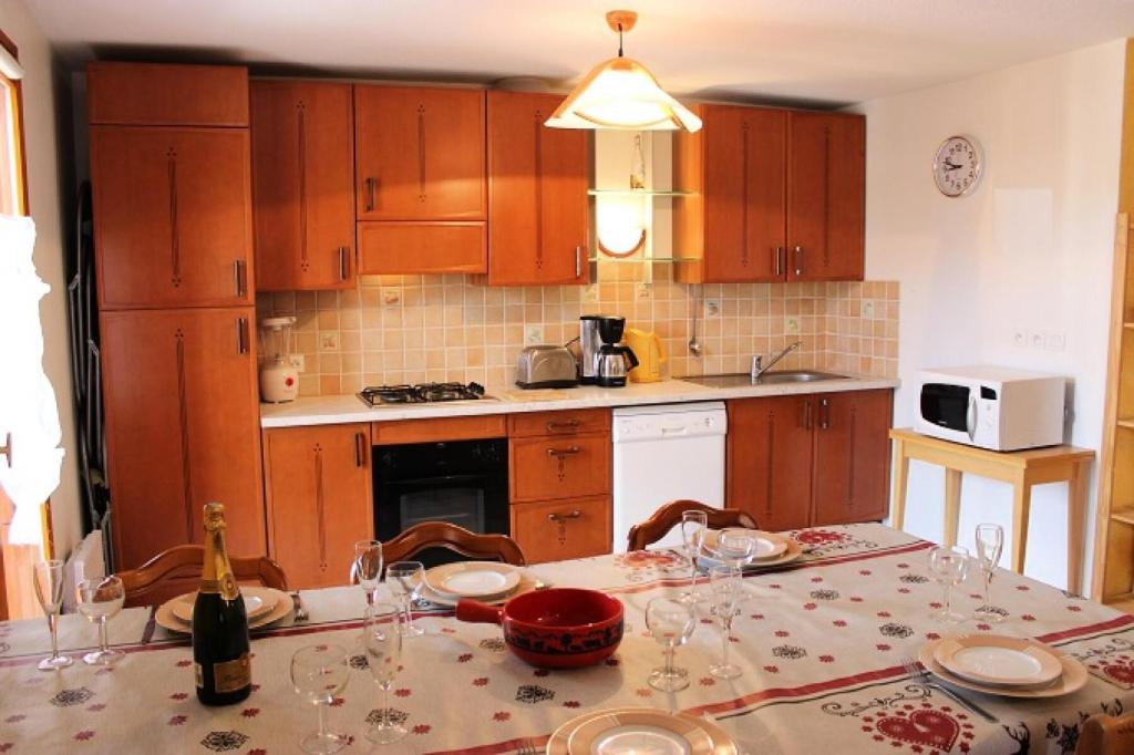 une cuisine avec une table avec des verres à vin dessus dans l'établissement Résidence Le Peclet - VAL THORENS SPACIEUX APPARTEMENT POUR 10 PERSONNES, EXPOSE SUD, BELLE VUE DEGAGEE MAE-7436, à Val Thorens