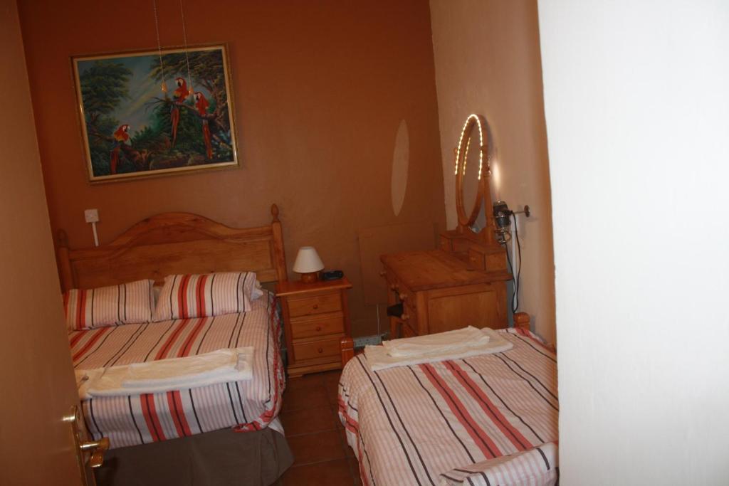 a bedroom with two beds and a painting on the wall at Governor's Inn Apartments in Gibraltar