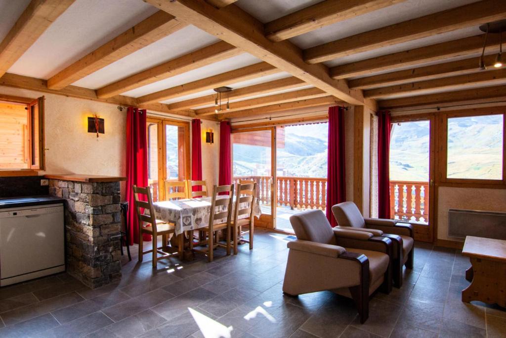 un salon avec une table et des chaises et une cheminée dans l'établissement Résidence Bouquetin - 3 Pièces pour 6 Personnes 48, à Val Thorens