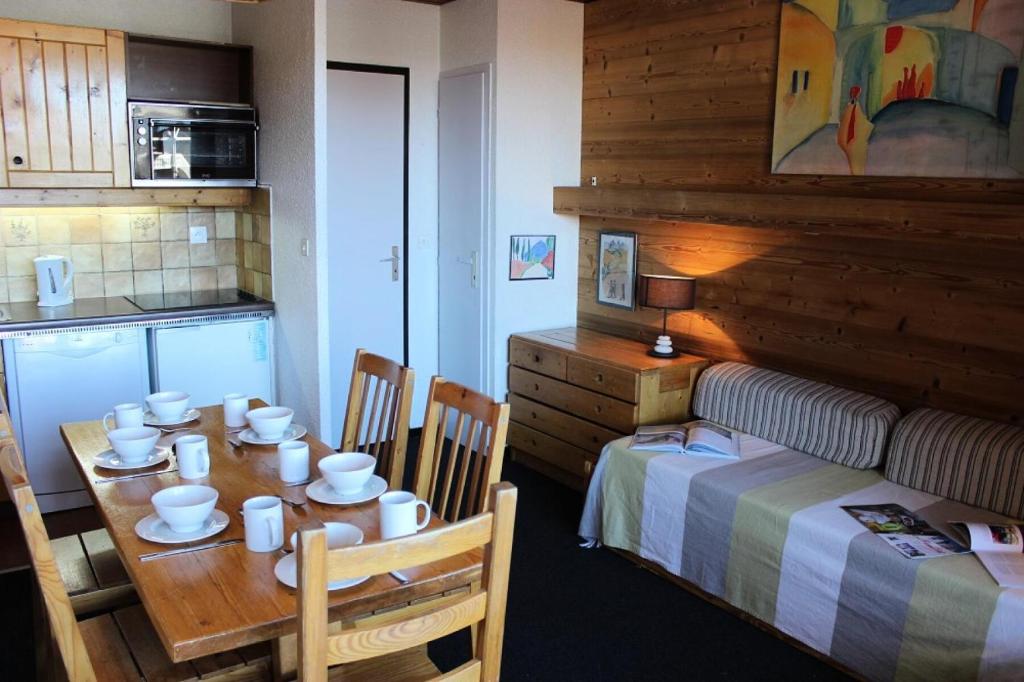 Cette chambre comprend une table, un lit et une cuisine. dans l'établissement Résidence Eterlous - ETERLOUS APPARTEMENT 35M² 6P BELLE VUE CENTRE STATION 59, à Val Thorens